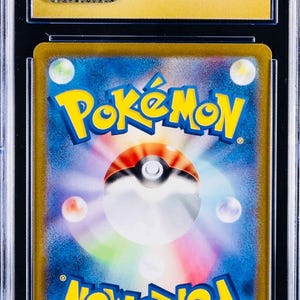 May include: A graded Pok&eacute;mon trading card in a clear protective case. The card displays the Pok&eacute;mon logo in yellow and blue, with a Pok&eacute; Ball design. The holder has a gold border and a CGC logo sticker.