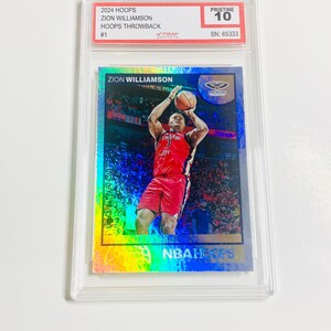 May include: A Zion Williamson basketball card from the 2024 Hoops Throwback series, graded Pristine 10. The card features a vibrant image of Williamson in a red uniform, mid-jump, with the text "ZION WILLIAMSON" and "NBA Hoops".