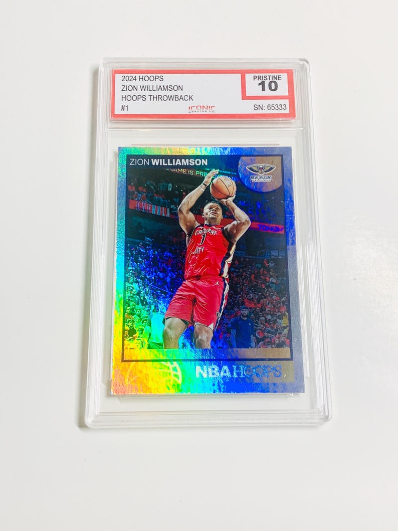 May include: A Zion Williamson basketball card from the 2024 Hoops Throwback series, graded Pristine 10. The card features a vibrant image of Williamson in a red uniform, mid-jump, with the text "ZION WILLIAMSON" and "NBA Hoops".