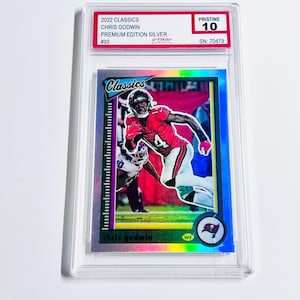 May include: A Chris Godwin football trading card from the 2022 Classics Premium Edition Silver set. The card is graded Pristine 10 and encased in a protective holder. The card features a player in a red and white uniform.