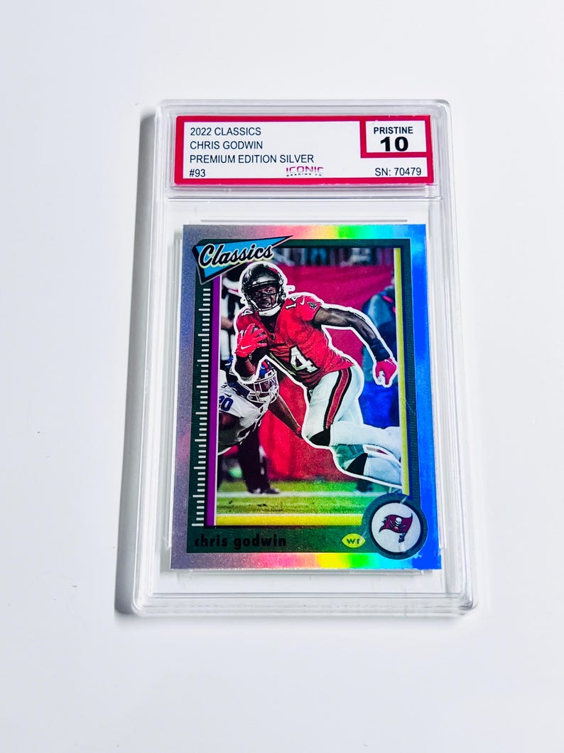 May include: A Chris Godwin football trading card from the 2022 Classics Premium Edition Silver set. The card is graded Pristine 10 and encased in a protective holder. The card features a player in a red and white uniform.