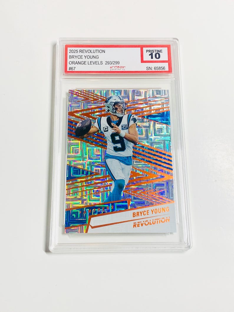 May include: A graded trading card featuring Bryce Young in a Carolina Panthers uniform. The card is from the 2025 Revolution series, Orange Levels 293/299, and is graded Pristine 10. The card has a serial number of 65856.