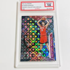 Puede incluir: Una tarjeta de baloncesto coleccionable con Alperen Sengun de los Houston Rockets. La tarjeta est&aacute; calificada como Pristine 10 y es de la serie 2021 Illusions Trophy Collection Circles. La tarjeta tiene un fondo hologr&aacute;fico.