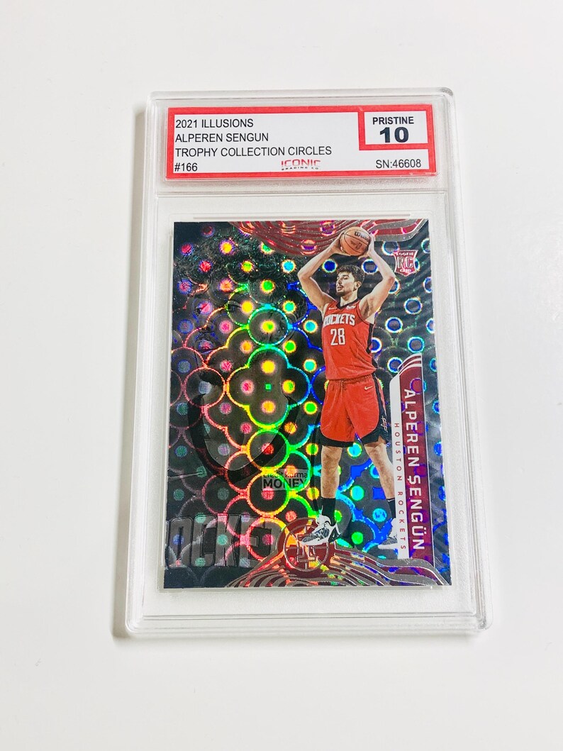 Puede incluir: Una tarjeta de baloncesto coleccionable con Alperen Sengun de los Houston Rockets. La tarjeta est&aacute; calificada como Pristine 10 y es de la serie 2021 Illusions Trophy Collection Circles. La tarjeta tiene un fondo hologr&aacute;fico.