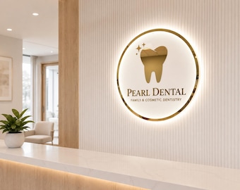May include: A circular, wall-mounted sign for Pearl Dental Family & Cosmetic Dentistry. The sign features a gold-colored tooth icon with two small stars above it, set against a white background with a glowing gold rim and dark lettering.