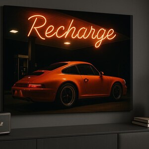 May include: Orange sports car parked under a neon sign that reads "Recharge." The car is the focal point, set against a dark background. The image is a canvas print, with a Marshall speaker in the foreground.