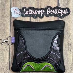 May include: Black zippered pouch with a green and black glitter Maleficent design. The pouch has a purple zipper pull and a silver key ring.
