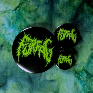 May include: Three black and green button badges with the word "FUNERAL" written in a stylised font.