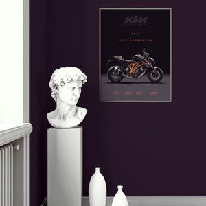 May include: A black and orange KTM 1290 Superduke motorcycle poster with the text "KTM Racing 2017 1290 Superduke" on a dark purple wall with a white plaster bust of a man on a gray pedestal and two white vases on the wooden floor.
