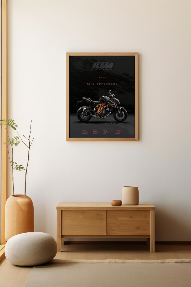 May include: A framed poster featuring a black and orange KTM 1290 Superduke motorcycle on a black background. The poster includes the text "KTM RACING 2017 1290 SUPERDUKE".