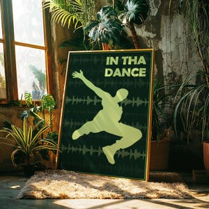 May include: A framed poster with the words "IN THA DANCE" and a lime green silhouette of a person dancing. The background is dark green with a sound wave pattern. The frame is gold.