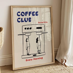 Puede incluir: Una impresión artística enmarcada con un fondo beige presenta las palabras "COFFEE CLUB" en azul, "Served Daily" y "Every Morning" en rojo. La ilustración representa dos figuras mirando una máquina de café.