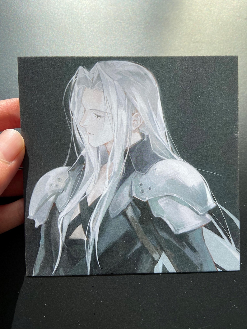 May include: A square art print featuring a side profile of a character with long, flowing silver hair. The character wears a black outfit with silver shoulder armor. The artwork is set against a dark background.