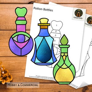 May include: A printable pattern for making stained glass potion bottles. The pattern includes three different bottle designs: a purple bottle with an eye, a blue bottle with a teardrop, and a yellow bottle with a diamond pattern. The pattern is labelled "Potion Bottles" and includes the text "Hobby & Commercial".