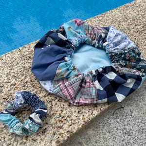 Pode incluir: Uma touca de banho de patchwork azul e branco com um scrunchie feito do mesmo tecido.