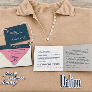 May include: A beige cashmere sweater with a ribbed collar and a row of small buttons. Included are several paper tags and cards with text including Dalton Cashmeres, Mitzi, size 40, and care instructions for the garment, plus a Dalton logo.