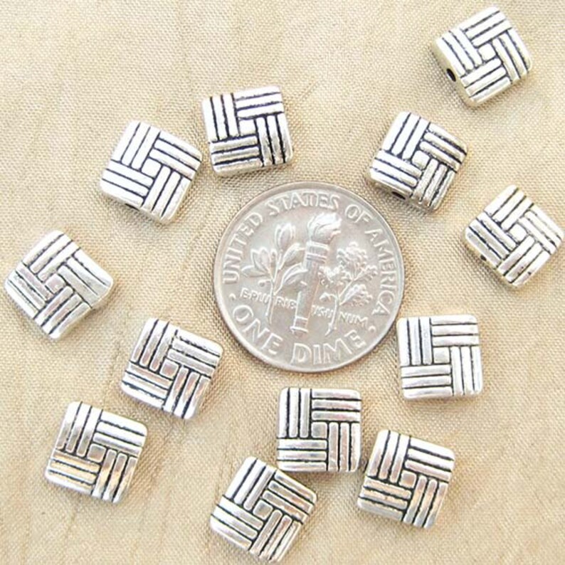 8 millimeter puff square beads with a basketweave design with U S dime for scale