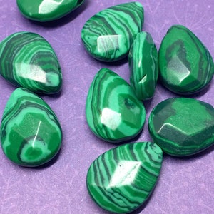 May include: A collection of eight green malachite gemstone beads in a teardrop shape. The beads have a faceted finish and are polished to a high shine.