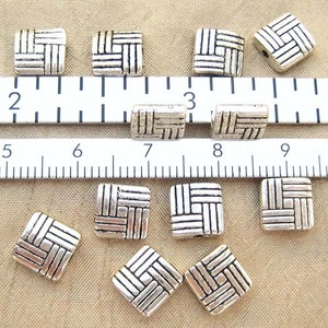 8 millimeter puff square beads with a basketweave design with standard and metric ruler for scale