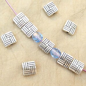 8 millimeter puff square beads with a basketweave design strung with 6mm fire polished crystal beads