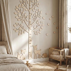 May include: Wooden tree wall decor with leaf cutouts, a fox, deer, and hedgehog. A wooden crib, toy train, and ride-on toy are also in the room. The room has a neutral color palette with beige curtains and a jute rug.