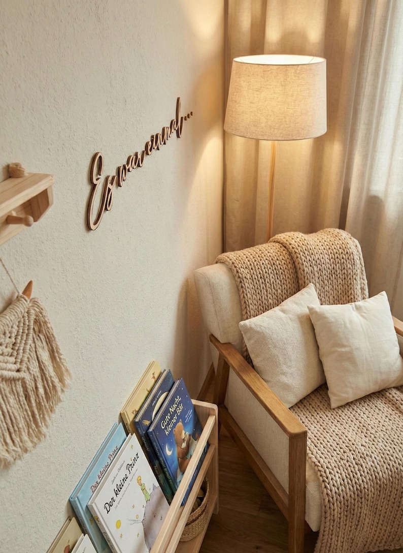 May include: A cozy reading nook with a wooden floor lamp and a beige armchair. The wall features a wooden sign that says "Erwasund..." and a small wooden shelf. A wooden bookshelf holds several children's books.