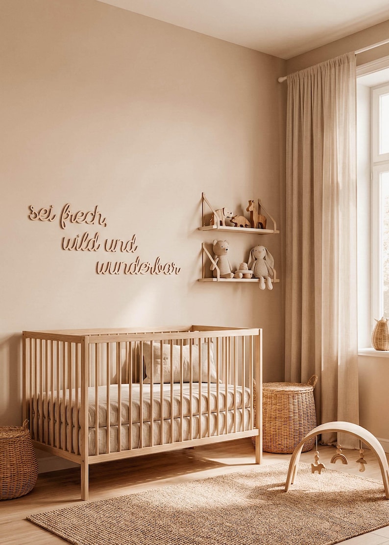 May include: A nursery room with a wooden crib, shelves, and a play gym. The walls are a neutral beige color, and the room is decorated with soft toys and a woven rug. The text "sei frech, wild und wunderbar" is on the wall.