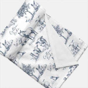 a white and blue patterned fabric with various farm animals, such as cows, horses, and sheep, depicted in a black and white illustration style.