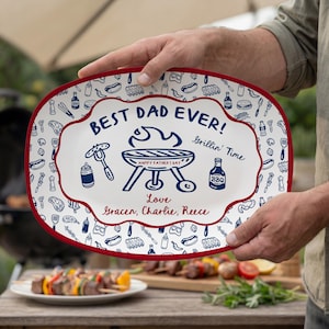 May include: An oval white serving platter with a red rim, featuring a blue graphic of a barbecue grill, the text "BEST DAD EVER!", "Grillin' Time", "HAPPY FATHER'S DAY", and "Love Gracen, Charlie, Reece" surrounded by a pattern of food and drink icons.