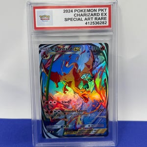 May include: A graded Pokemon trading card featuring Charizard EX, a fiery orange dragon Pokemon with a blue and white background. The card is a Special Art Rare and has a grade of 412536282. The card has a power of 180 and features attacks like Slash and Crimson Storm.