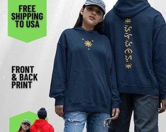 Puede incluir: Dos sudaderas con capucha azul marino con una estrella dorada y texto en la parte delantera y trasera. La sudadera con capucha de la izquierda tiene una estrella dorada de ocho puntas y el texto "FREE SHIPPING TO USA" en la parte delantera. La sudadera con capucha de la derecha tiene una estrella dorada de ocho puntas y una línea vertical de texto dorado en la parte trasera. La sudadera con capucha de la izquierda la lleva puesta una persona con el pelo oscuro y una gorra azul marino. La sudadera con capucha de la derecha la lleva puesta una persona con el pelo oscuro y una boina azul marino.