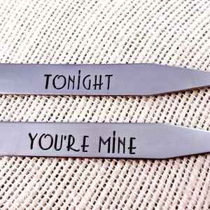 May include: Two silver collar stays with the words "Tonight" and "You're Mine" engraved on them.