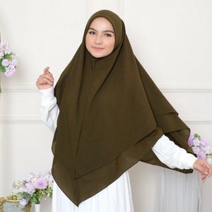 May include: A dark green hijab with a simple, elegant design. The hijab is made of a soft, flowing fabric and is perfect for everyday wear.