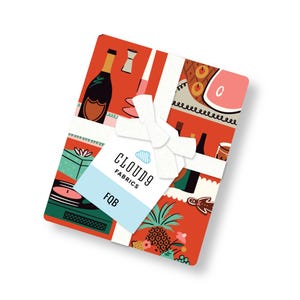 May include: A stack of folded fabric with a vibrant red background featuring illustrations of champagne bottles, pineapples, records, and food items. A white ribbon ties the bundle, holding a tag that reads CLOUD9 FABRICS and FQB.