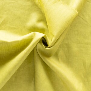 May include: A close-up of a crumpled piece of fabric. The fabric is a light green color and has a smooth texture.