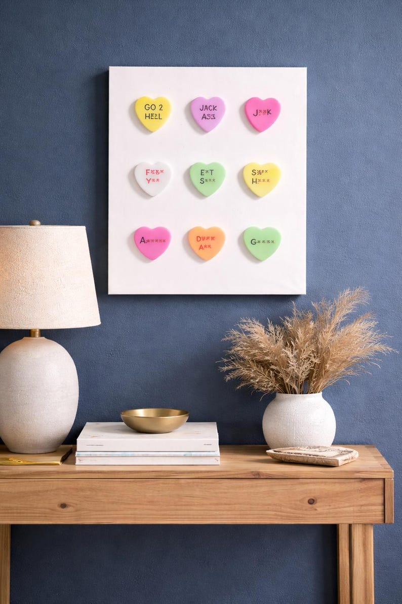 May include: A set of three ceramic mugs with a speckled, cream-colored glaze. Each mug features a different hand-painted design: a blue and green leaf, a yellow and orange flower, and a red and pink berry. The mugs have a simple, rounded shape.