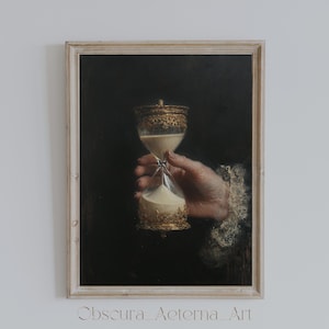 May include: A framed vintage-style print featuring an hourglass held by a hand. The hourglass has ornate gold detailing and contains white sand. The background is dark, and the frame is a light beige color. The print is labeled "Obscura Aeterna Art".