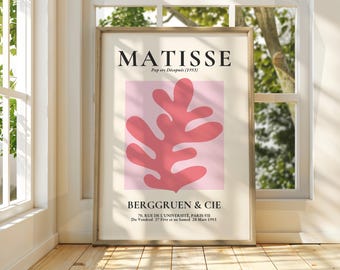 Op de afbeelding: Een ingelijste poster met een roze achtergrond en een grote, rode, abstracte bladsvorm. De poster heeft de titel "MATISSE" en bevat de tekst "Papers Découpés (1953)" en "BERGGRUEN & CIE".