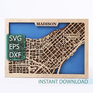 Puede incluir: Un mapa de madera de Madison, Wisconsin, con un fondo azul y el texto "OLD MARKET PLACE" y "GREENBUSH". El mapa está enmarcado en madera y tiene el texto "MADISON" y "INSTANT DOWNLOAD" en la parte superior e inferior, respectivamente. El texto "SVG EPS DXF" está en un cuadro verde en el lado izquierdo del mapa.