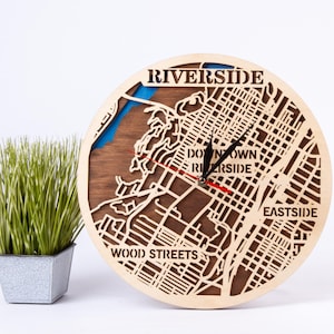 May include: A wooden clock with a map of Riverside, California. The clock face features the words "Riverside", "Downtown Riverside", "Eastside", and "Wood Streets".