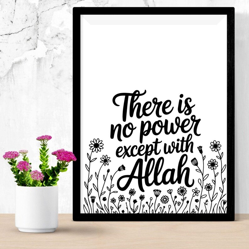 May include: A framed black and white print with the text "There is no power except with Allah." The print features floral illustrations at the bottom. A small white vase with pink flowers sits to the left of the frame.