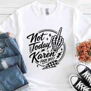 K&ouml;nnte beinhalten: Wei&szlig;es T-Shirt mit schwarzem Aufdruck: "Not Today, Karen FUCK OFF!". Das Design zeigt eine Skeletthand, die den Mittelfinger zeigt, sowie Blitze und ein Schachbrettmuster. Das Shirt wird mit blauen Jeans und schwarz-wei&szlig;en Turnschuhen pr&auml;sentiert.