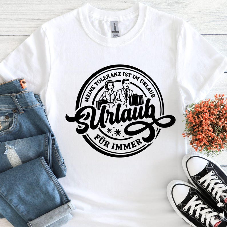 May include: White t-shirt with a black graphic. The graphic features a vintage illustration of a couple with luggage, and the German text "Meine Toleranz ist im Urlaub f&uuml;r immer."