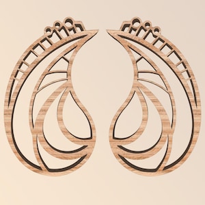 May include: Two wooden earrings with a leaf-like design. Each earring has a teardrop shape with intricate cut-out patterns and a decorative top. The wood grain is visible, and the earrings are set against a neutral background.