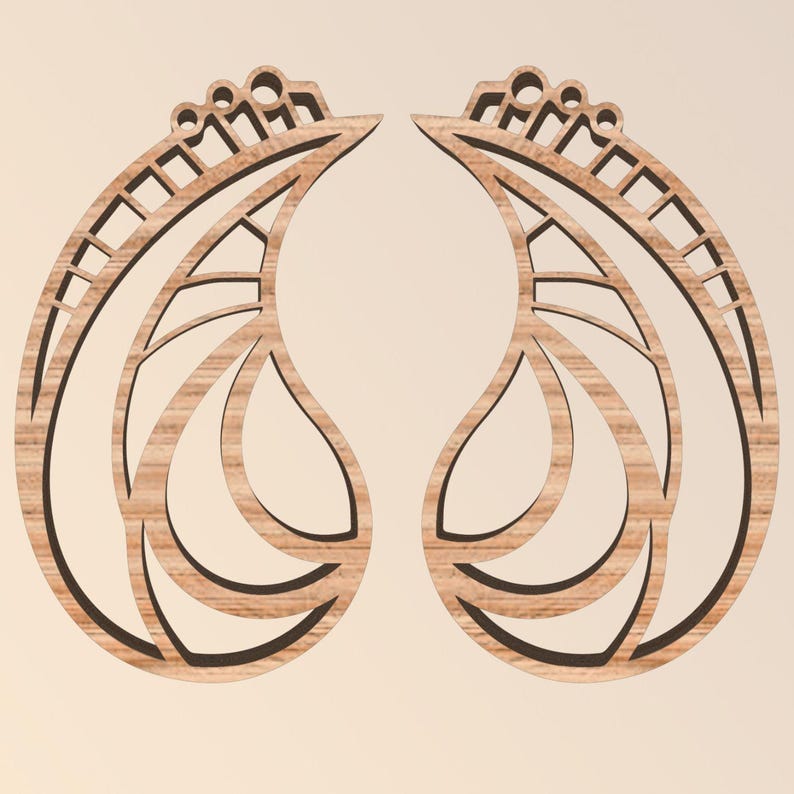 May include: Two wooden earrings with a leaf-like design. Each earring has a teardrop shape with intricate cut-out patterns and a decorative top. The wood grain is visible, and the earrings are set against a neutral background.