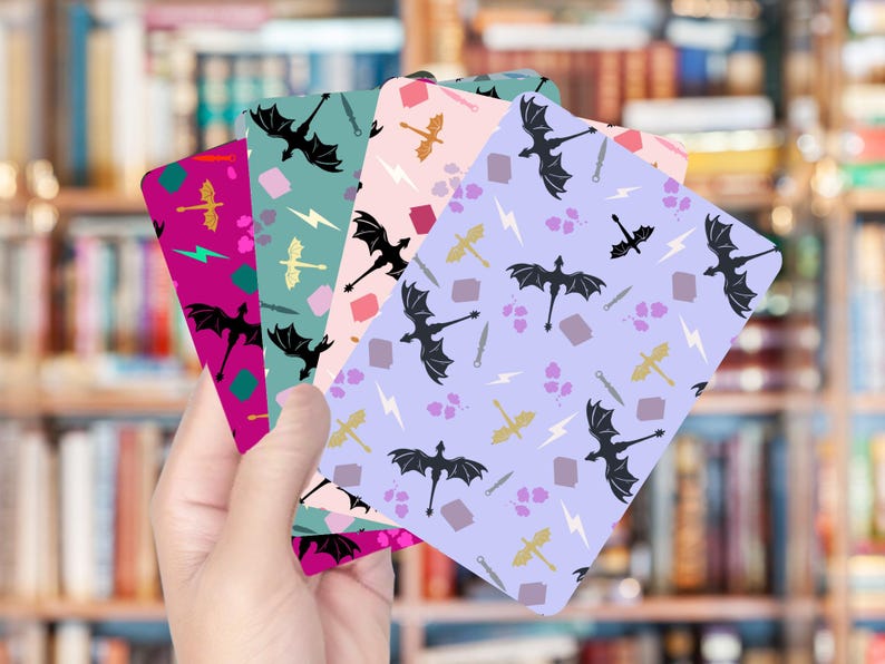 May include: A hand holds a fan of colorful cards with dragon and fantasy-themed patterns. The cards feature dragons, swords, lightning bolts, and other fantasy elements in shades of purple, pink, green, and teal.