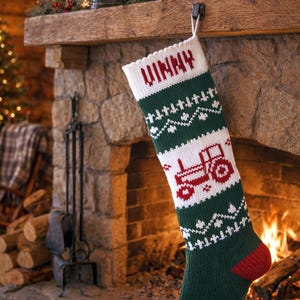 May include: A green and white knitted Christmas stocking with the name "VINNY" in red letters. The stocking features a red tractor design and a red heel and toe. It hangs from a fireplace mantel.