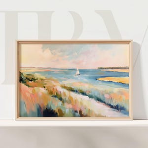 May include: Coastal landscape painting in a light wood frame. The artwork depicts a sailboat on blue water, with colorful brushstrokes of pink, yellow, and green representing the marsh and sky. A serene, decorative piece.