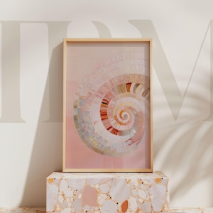 Peut inclure: Impression d'art encadrée avec un motif en spirale dans des tons de rose, blanc et orange. L'œuvre est présentée dans un cadre en bois clair et exposée sur un piédestal de style terrazzo.