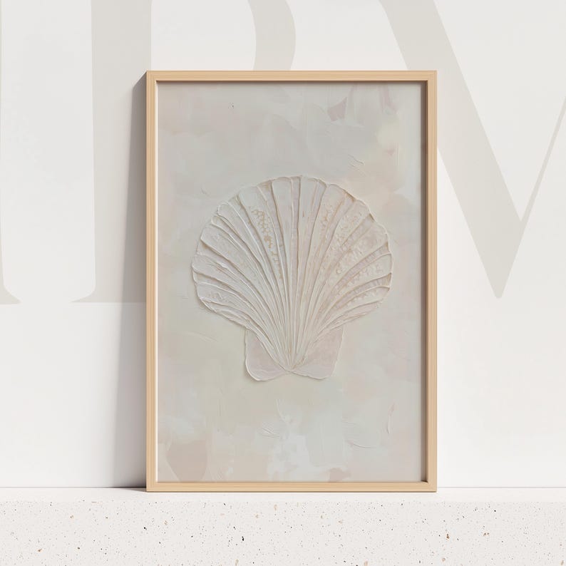 K&ouml;nnte beinhalten: Gerahmtes Kunstwerk mit einem strukturierten, cremefarbenen Muscheldesign. Die Muschel ist der Mittelpunkt, vor einem weichen, neutralen Hintergrund mit einem hellen Holzrahmen. Das Kunstwerk erinnert an ein K&uuml;sten- oder Strandthema.